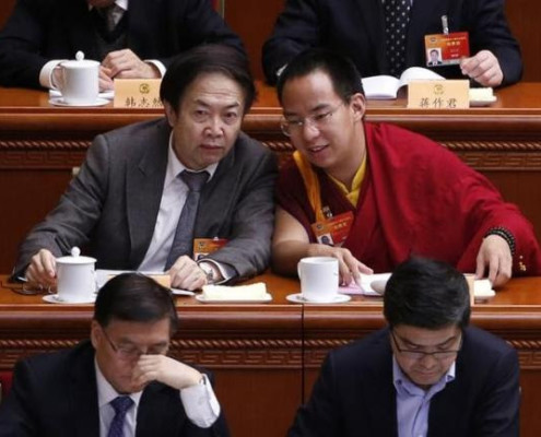 Gyaltsen Norbu (R), the 11th Panchen Lama, speaks with a delegate ahead of the opening of the third plenary meeting of Chinese People's Political Consultative Conference (CPPCC) at the Great Hall of the People in Beijing, March 11, 2015. REUTERS/KIM KYUNG-HOON